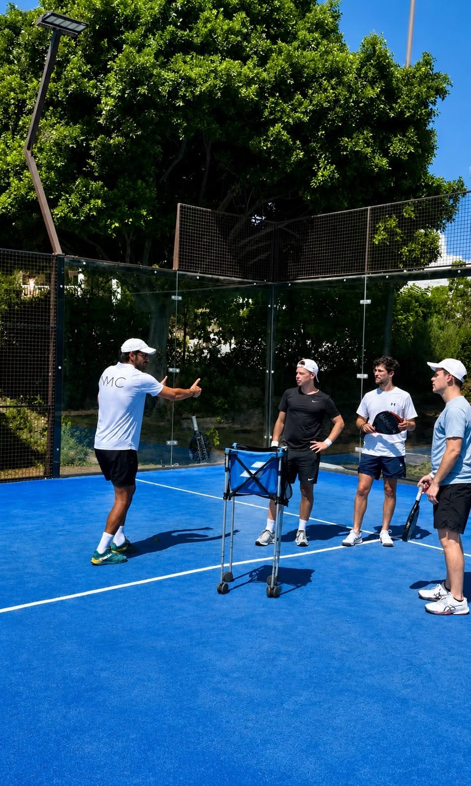 Entrenador dando indicaciones a un grupo de jugadores en pista