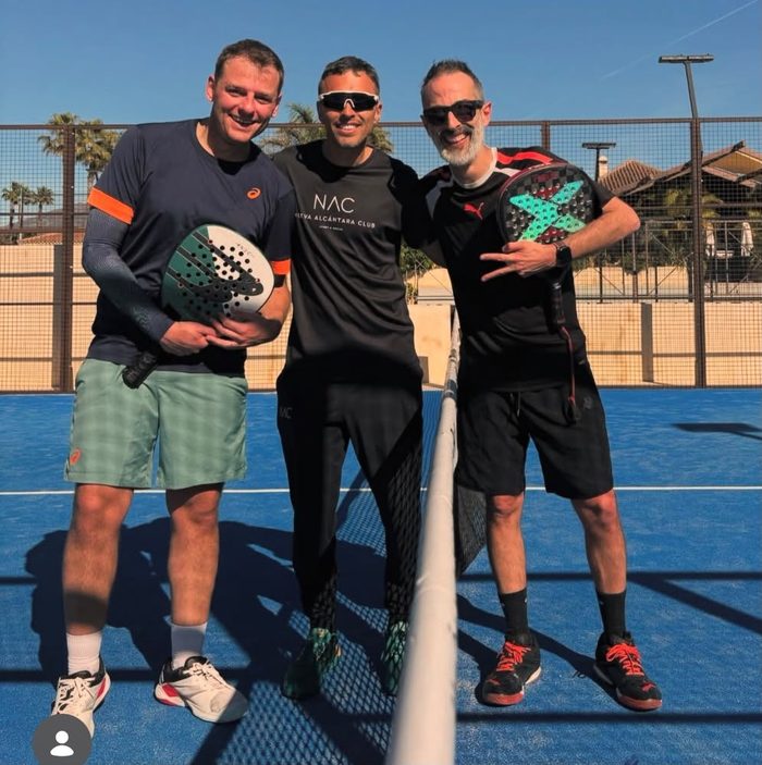 Tres jugadores posando junto a la red de la pista